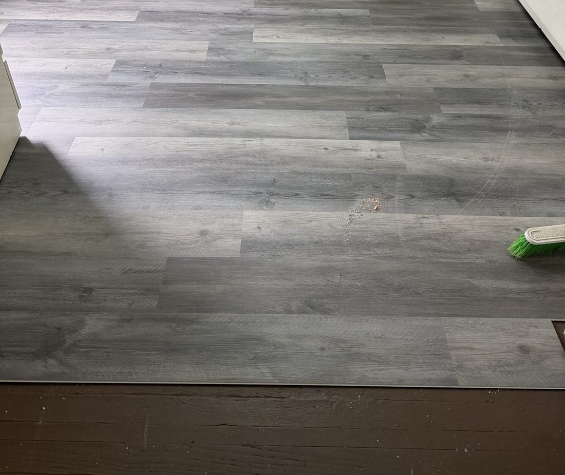 Gray wood-look flooring installed across visible room area