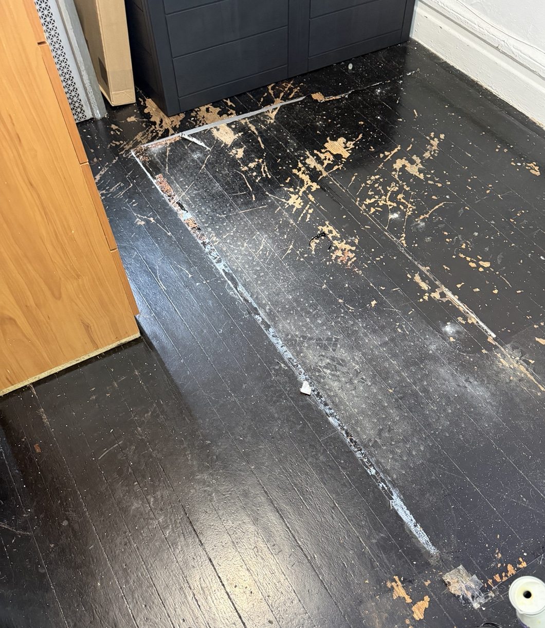 Dark-painted floor with extensive finish loss