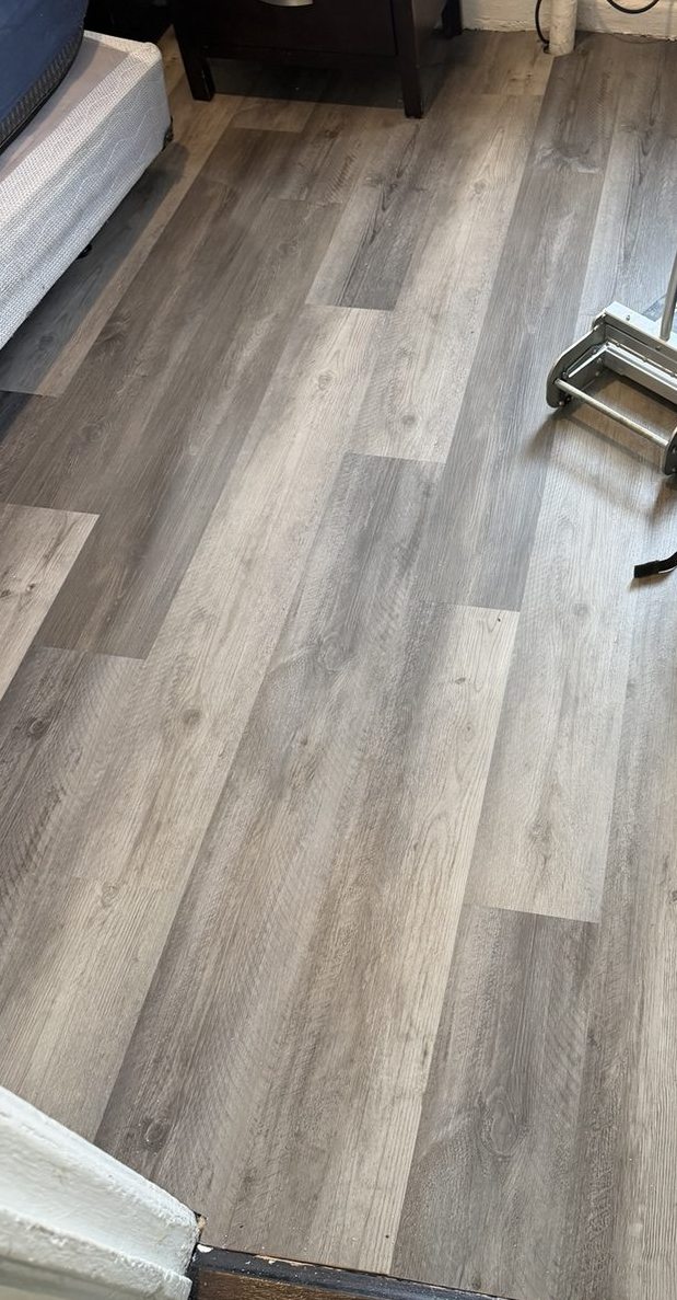 Plank installation tools with part of gray flooring in place